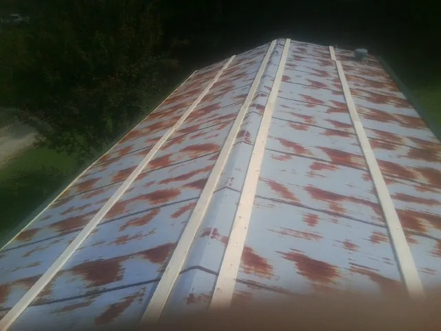 Rusted metal roof panels with new wood purlins before replacement — Storm Damage Roof Repair in Hinckley by Roofing Brothers