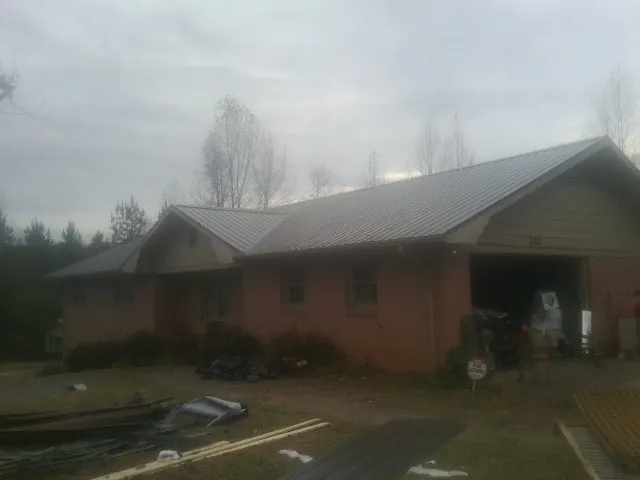 Gray metal roof on a stucco house with an attached garage in Hinckley