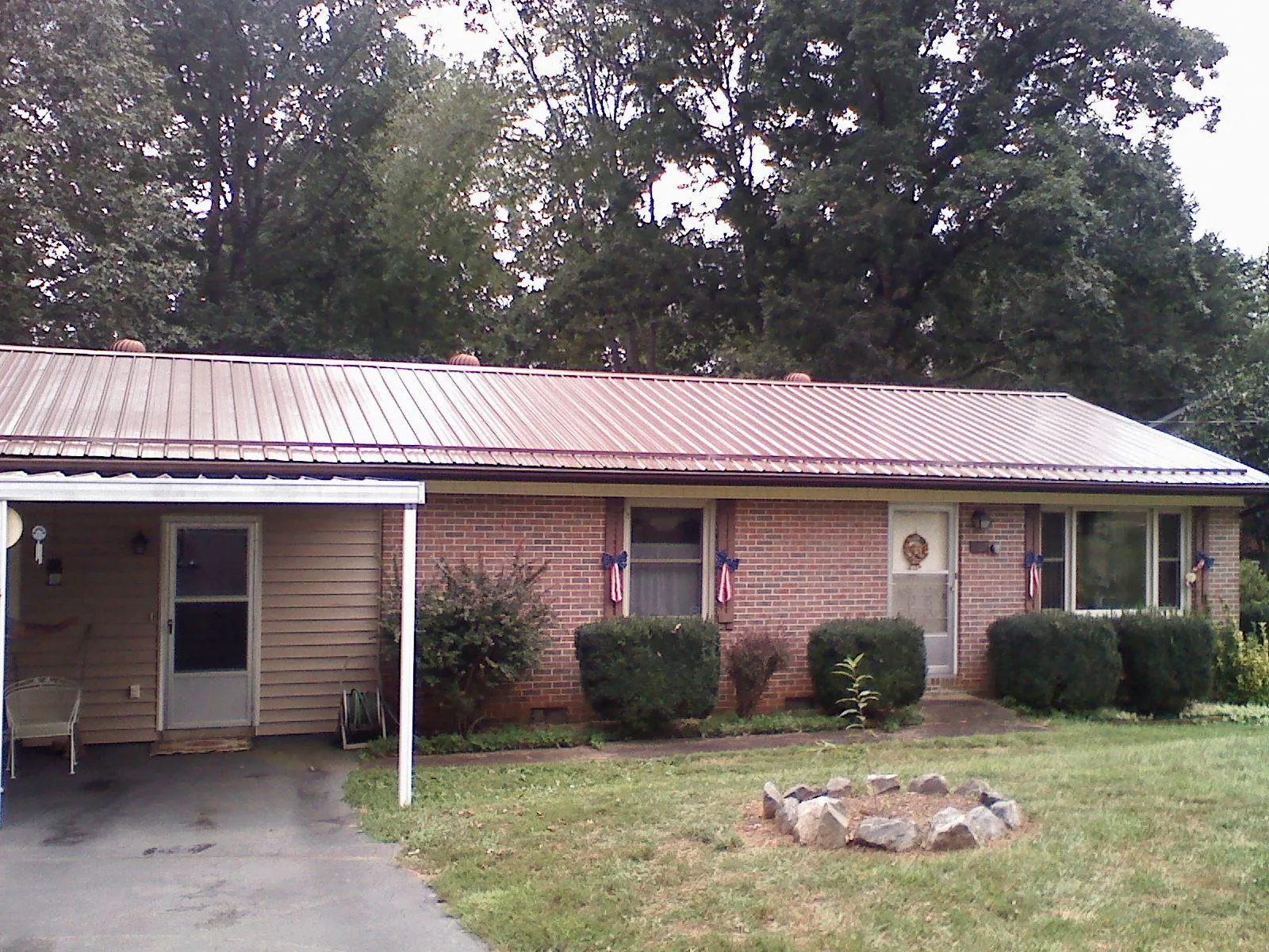 Bronze metal roof and carport on a brick ranch home — Roof Repair work by our crew in Hinckley